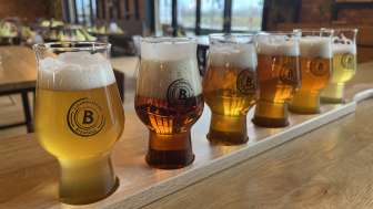 Verschiedene Biersorten in einem Verkostungsset auf einem Holztisch – von hellem bis dunklem Bier, serviert in stilvollen Gläsern in der Liechtensteiner Braustube