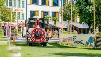 Citytrain fährt durch Vaduz auf grünem Kunstrasen beim Sommertreff in Vaduz